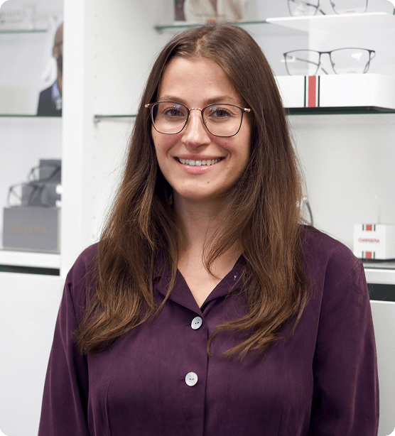 Alt Text: Dr. Brittney Gewolb, Lackawanna optometrist, wearing glasses in front of a display of optical frames.